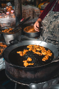 Midsection of person preparing food on barbecue grill