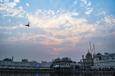 Airplane flying over city against sky