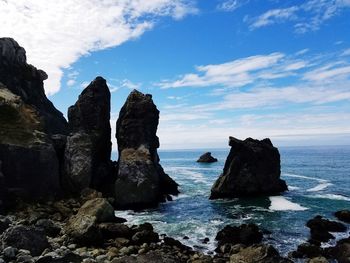 Rock formations by sea against sky