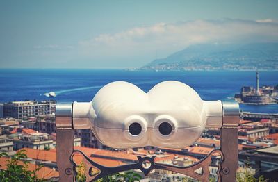 Close-up of sea and cityscape against sky