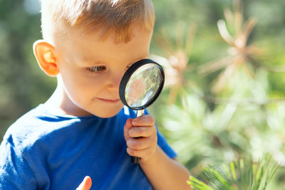 Boy holding magnifying glass