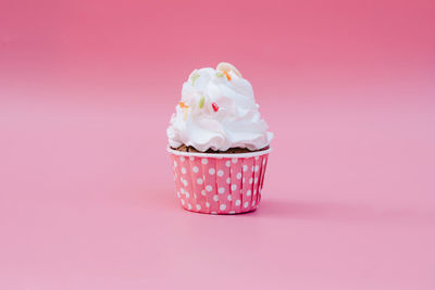 Close-up of ice cream cone against pink background