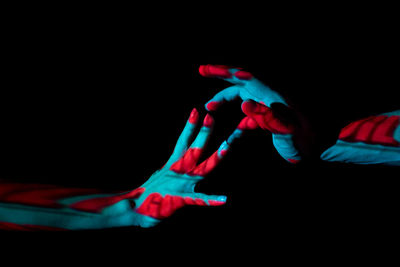 Close-up of two hands against black background