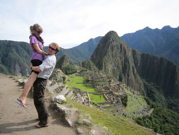 Man carrying woman against machu picchu