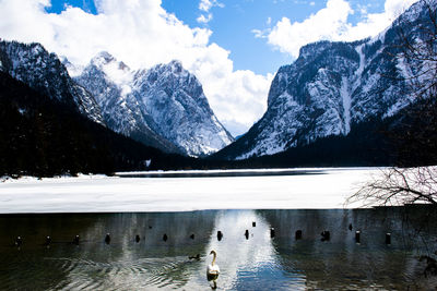 Scenic view of lake by snowcapped mountains against sky