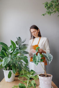 Portrait of woman holding potted plant