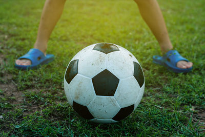 Low section of boy playing soccer on grass