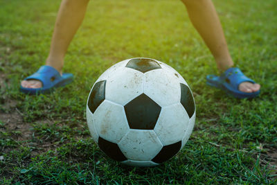 Low section of child with ball on field