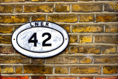 House number 42 in an old railway sign on a brick wall in london