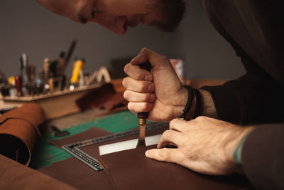 Hot tool. tanner makes leather purse. diy instruction, indoors, closeup, authentic. eco 