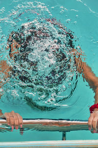 Midsection of man playing in swimming pool