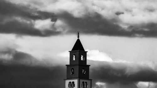 Low angle view of clock tower amidst buildings against sky