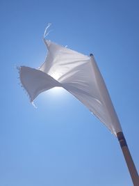 Low angle view of umbrella against clear blue sky