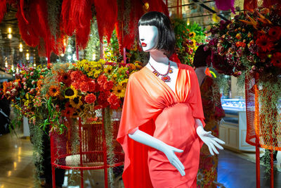 Fashion female clothes on mannequin in decorative flower booth