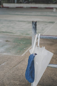 Close-up of umbrella and bag on railing