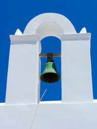 Low angle view of cross against blue sky on sunny day