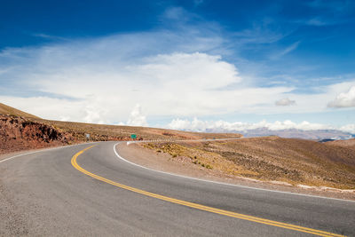 Empty road along landscape against sky