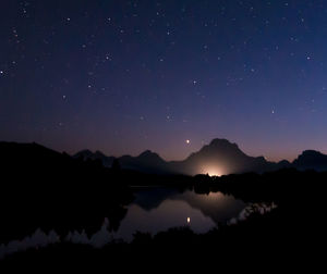 Scenic view of silhouette mountains against sky at night
