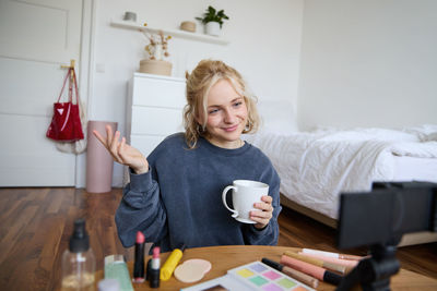 Portrait of young woman using mobile phone at home