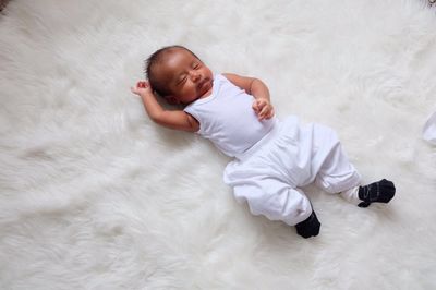 High angle view of baby sleeping while lying on soft fur at home