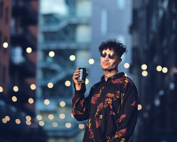 Full length of man standing against illuminated city at night