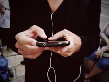 Midsection of man using mobile phone