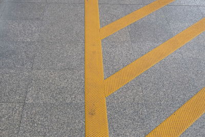 High angle view of yellow arrow symbol on road