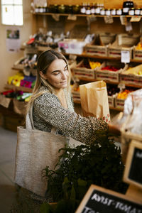 Woman doing shopping in shop with organic food