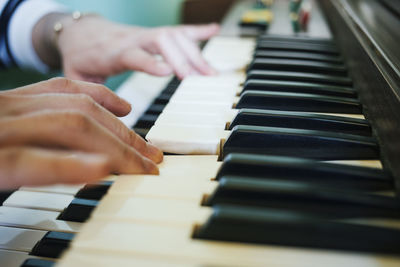 Cropped hands playing piano