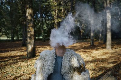 Man smoking while sitting in forest