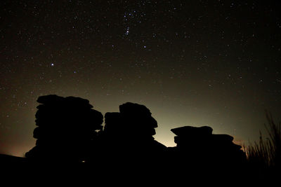 Silhouette of little mis tor on dartmoor with stars in the sky 