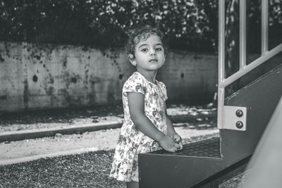 Portrait of girl standing by jungle gym at park