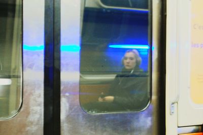 Reflection of woman on window in bus