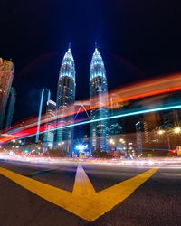 Light trails on city street against buildings at night