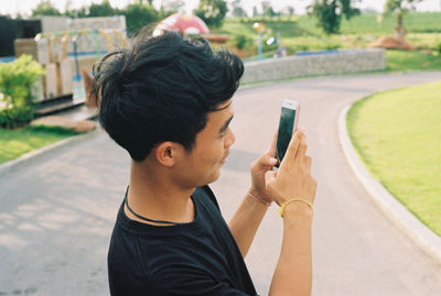 Young man using mobile phone outdoors