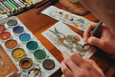 Cropped image of woman painting easter bunny