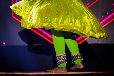 Rear view of woman standing by multi colored umbrella