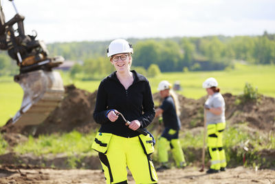 Female worker with digger on background