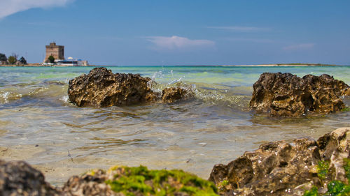 Rock formation on beach against sky