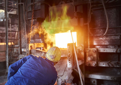 Industry, smeltery: worker checking blast furnace for fractures