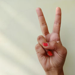 Close-up of hand gesturing against wall