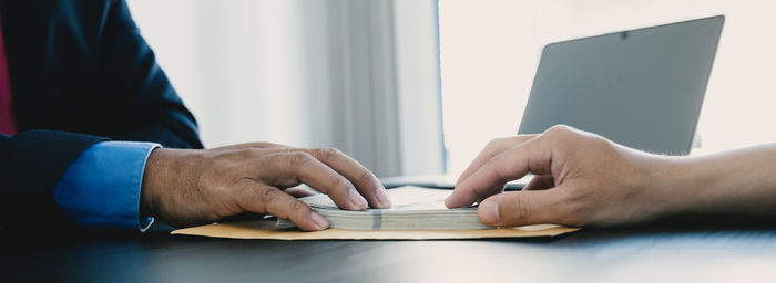 Close-up of man using laptop on table