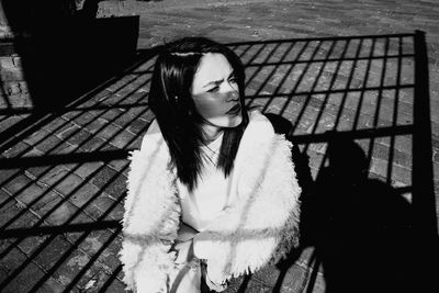 Young woman wearing fur sitting outdoors