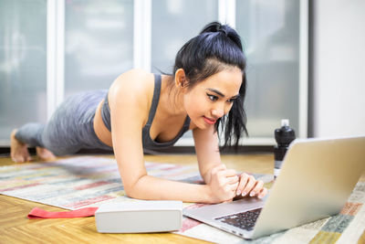 Young woman using mobile phone at home