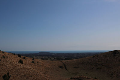 Scenic view of desert against clear blue sky