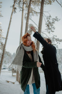 Woman standing on snow covered tree