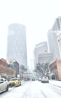 Snow covered city against clear sky