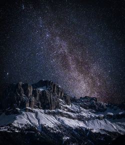 Scenic view of snowcapped mountains against sky at night