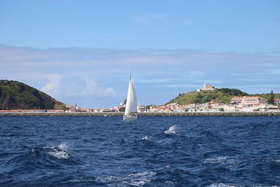 Sailboats in sea against sky