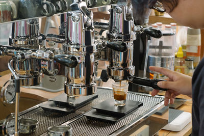 Cropped image of barista making coffee in cafe